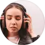 A woman with closed eyes holding her headphones